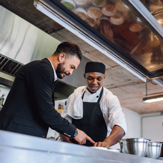 Two chefs working together in a professional kitchen.