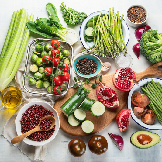 Assorted fresh vegetables and fruits on a light surface