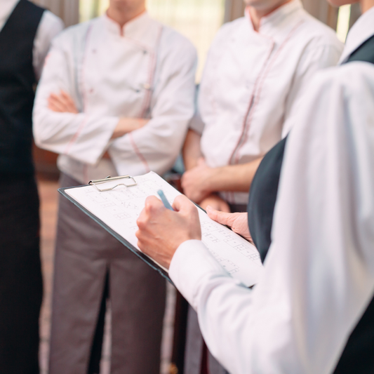 Group of people in formal attire with a person holding a clipboard.